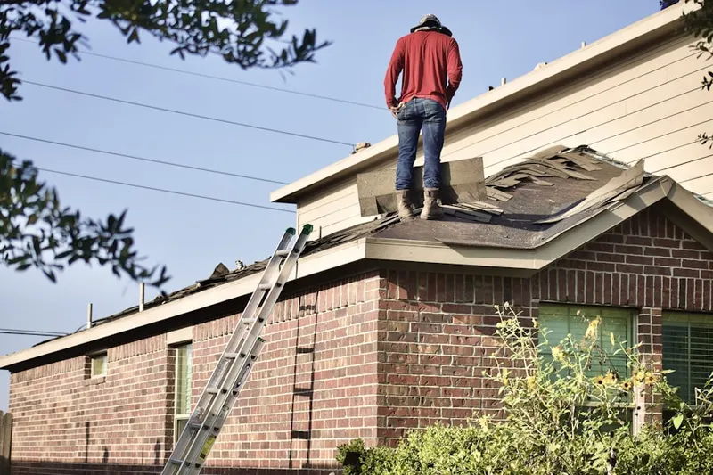 Professional roofer working on a residential roof in Perico